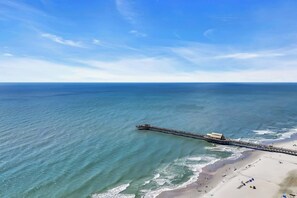 An aerial view of a beach with a long pier extending into the ocean. - Ocean View Resort Condo w Private Master Suite (Myrtle Beach)