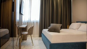 A hotel room with a bed, a desk, a chair, and a TV. - Maison D'élite (Naples)
