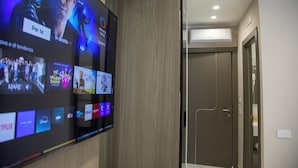 A hotel room with a large flat-screen TV displaying various streaming services. - Maison D'élite (Naples)