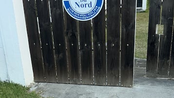 Une porte en bois sur laquelle est apposée une plaque indiquant « Breeze du Nord » et mentionnant les coordonnées.