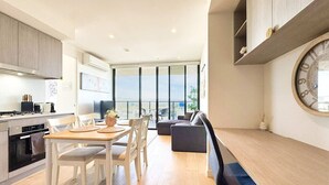 Una cocina moderna con comedor, un amplio ventanal y un reloj de pared redondo.