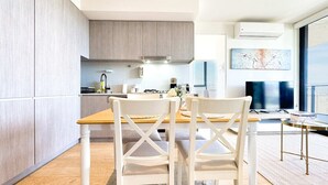 Una cocina moderna con armarios de madera, una isla central y sillas blancas.