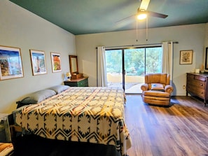 A bedroom with a bed, a chair, a dresser, and a window with a view of trees. - Authentic Desert Vibes 3-bedroom house with pool & AC in charming Cave Creek (Cave Creek)