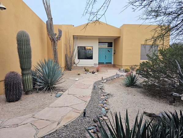 A desert-style house with a paved pathway, cacti, and a blue door. - Authentic Desert Vibes 3-bedroom house with pool & AC in charming Cave Creek (Cave Creek)