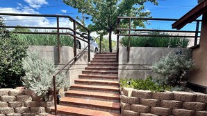A staircase leading up to a building with a metal railing and a concrete wall.