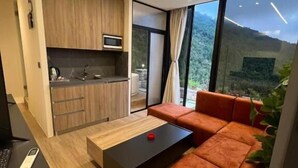 Un espace de vie moderne comprenant un canapé, une table basse et un coin cuisine.