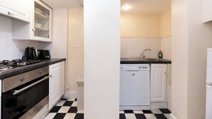A kitchen with a black and white checkered floor, white cabinets, a stove, a dishwasher, and a sink. - Two Bedroom Flat - Next to West Kensington Station - Pass the Keys (London)