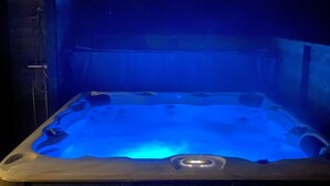 Ein Whirlpool mit blauem Licht, umgeben von einem dunklen Innenraum.