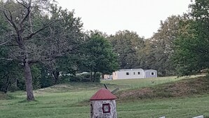 Una pequeña estructura parecida a una torre, con techo rojo, rodeada por un camino de hormigón y una zona cubierta de césped.