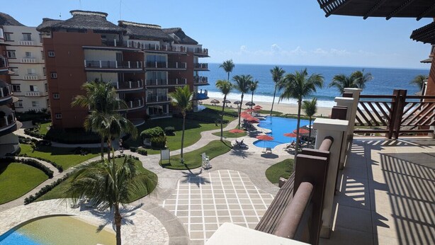 A resort with a pool, palm trees, and a view of the ocean. - Two Bedroom Ocean View (Bajos de Chila)