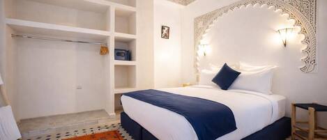 Une chambre à coucher avec un lit, une armoire et un tapis à motifs.