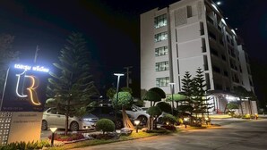 A multi-story hotel building with a sign indicating 'The Room' and a contact number. - The Room Premium Hotel Chiangrai  (Chiang Rai)