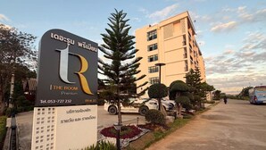 A hotel sign with a modern design, a contact number, and a building in the background. - The Room Premium Hotel Chiangrai  (Chiang Rai)