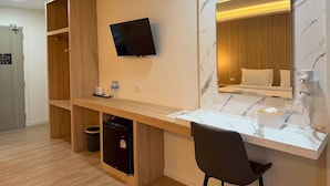 A hotel room with a TV, a desk with a chair, a minibar, a mirror, and a wooden wardrobe. - The Room Premium Hotel Chiangrai  (Chiang Rai)