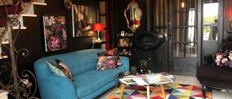 A living room with a blue sofa, a coffee table, and a colorful geometric rug.