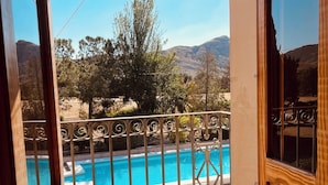 Blick von einem Balkon mit Schwimmbad, Metallgeländer und Holztür.