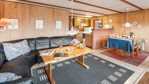 A cozy living room with a leather sofa, a wooden coffee table, and a dining area with a table set for four. - "Samine" - 1.2km from the sea by Interhome (Blåvand)