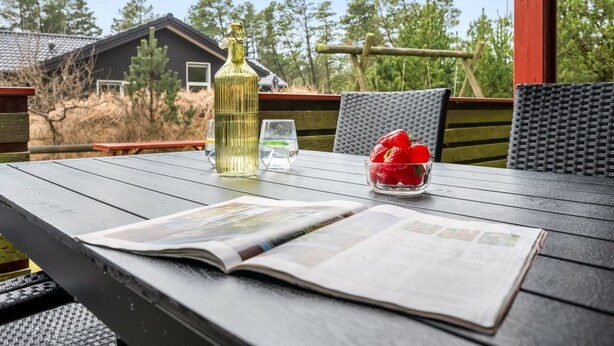An outdoor wooden table with a magazine, a bottle, and a bowl of strawberries. - "Samine" - 1.2km from the sea by Interhome (Blåvand)
