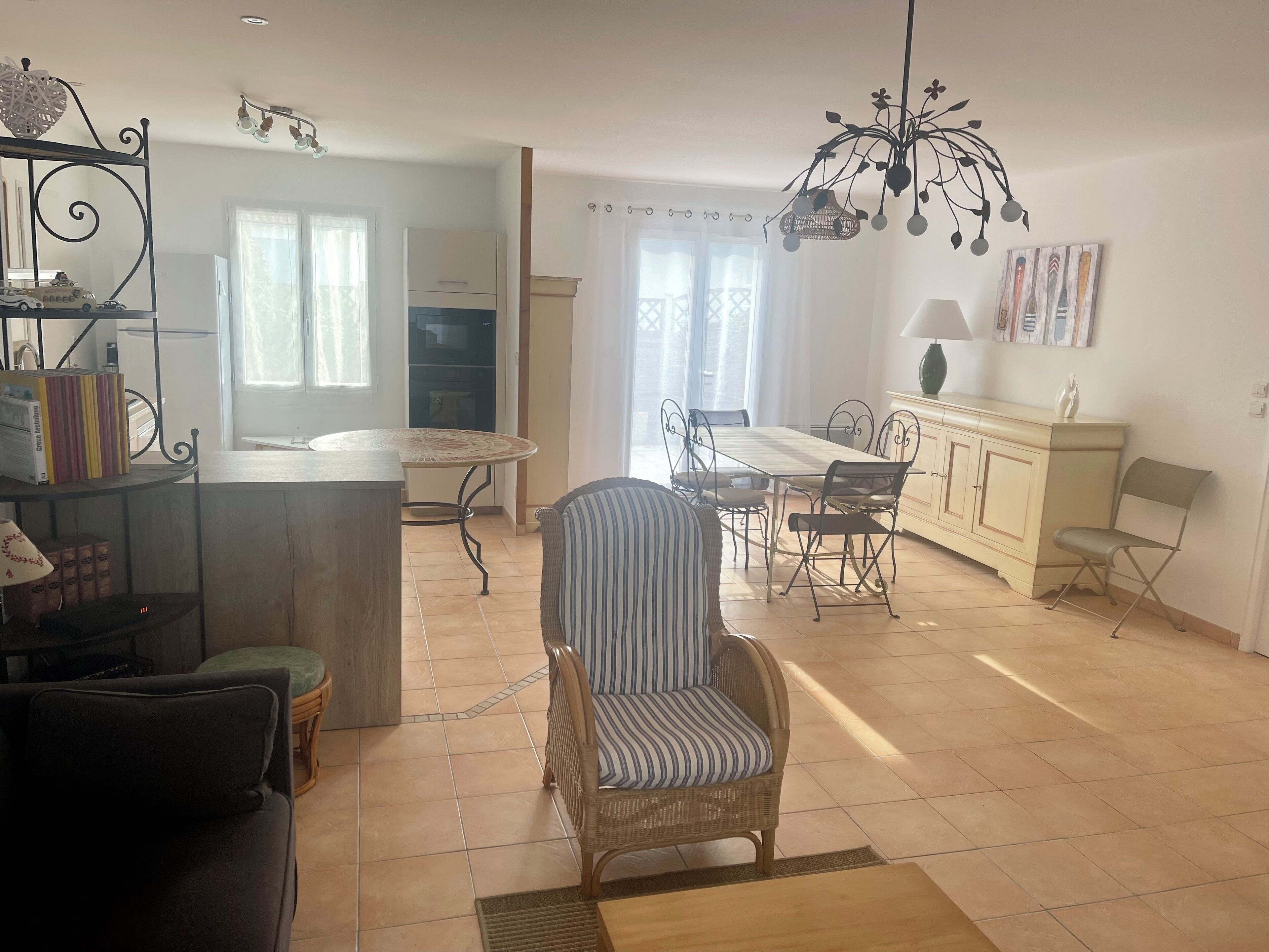 Un vaste espace de vie comprenant une table à manger, des chaises, un canapé et un fauteuil décoratif.