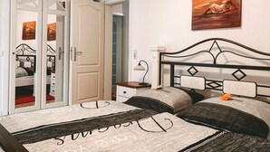 Un dormitorio con cama, mesita de noche, espejo y armario.