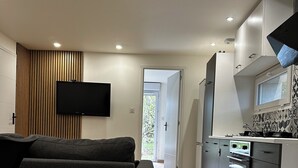 A modern kitchen with a built-in oven and a flat-screen TV mounted on the wall.