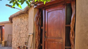A rustic building with a wooden door, stone walls, and traditional pottery. - Masairiatacama.cl (San Pedro de Atacama)
