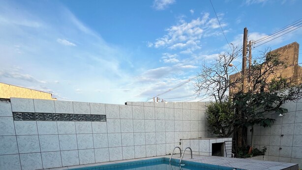 A swimming pool with tiled walls and a clear blue sky. - Complete House with Private Pool and BBQ | Praia Grande (Praia Grande)