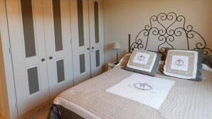 Una camera da letto con un letto, un comodino, una lampada e un armadio.
