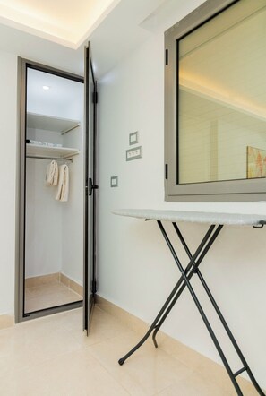 A room with a walk-in closet, a large mirror, and a foldable ironing board. - Enjoy an unforgettable stay in this bright apartment with terrace (Mahdia)