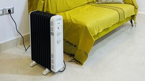 Habitació amb un sofà groc, un radiador i una finestra amb vidre mossegat.