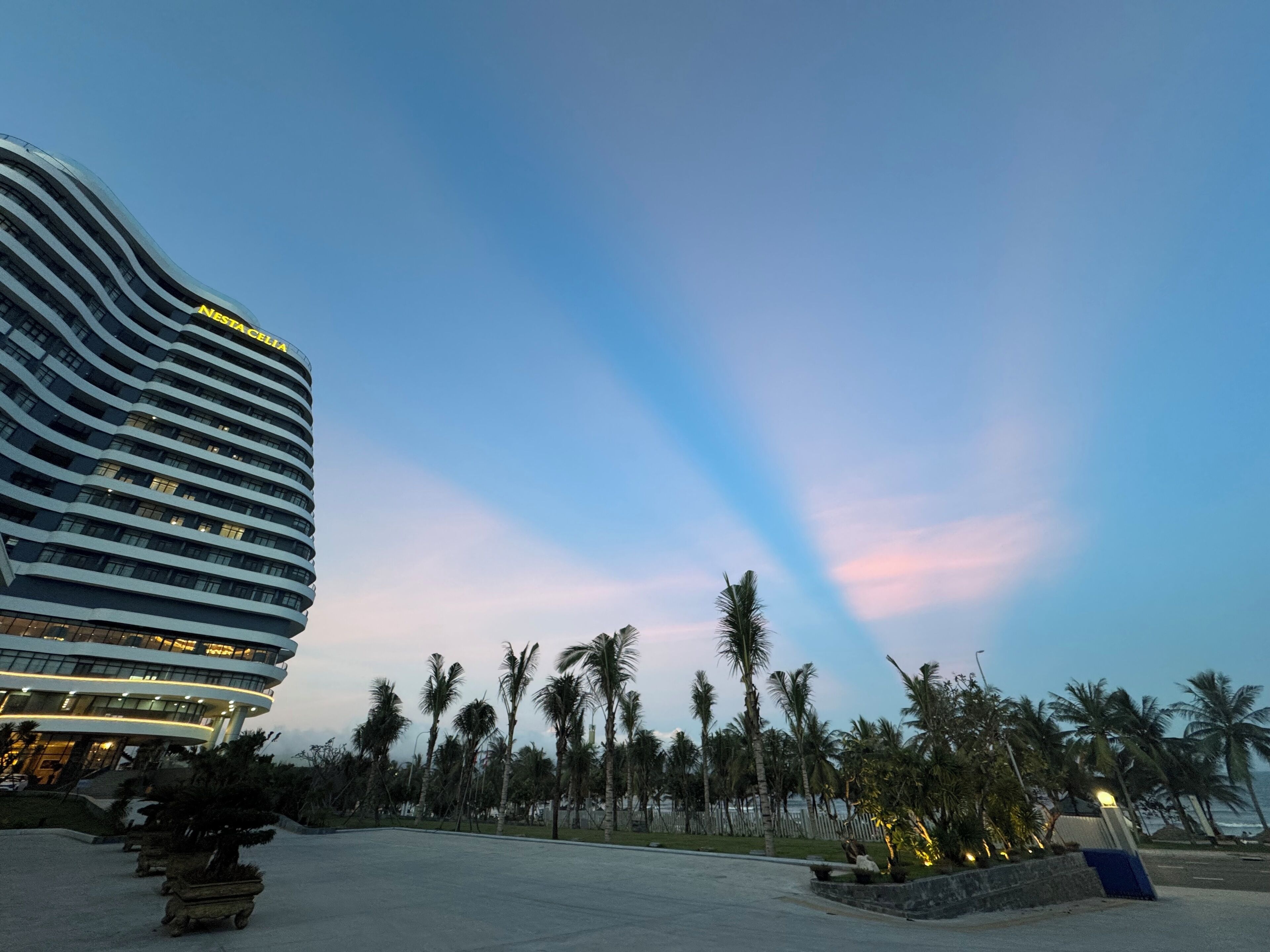 A modern hotel with a curved facade and multiple balconies.