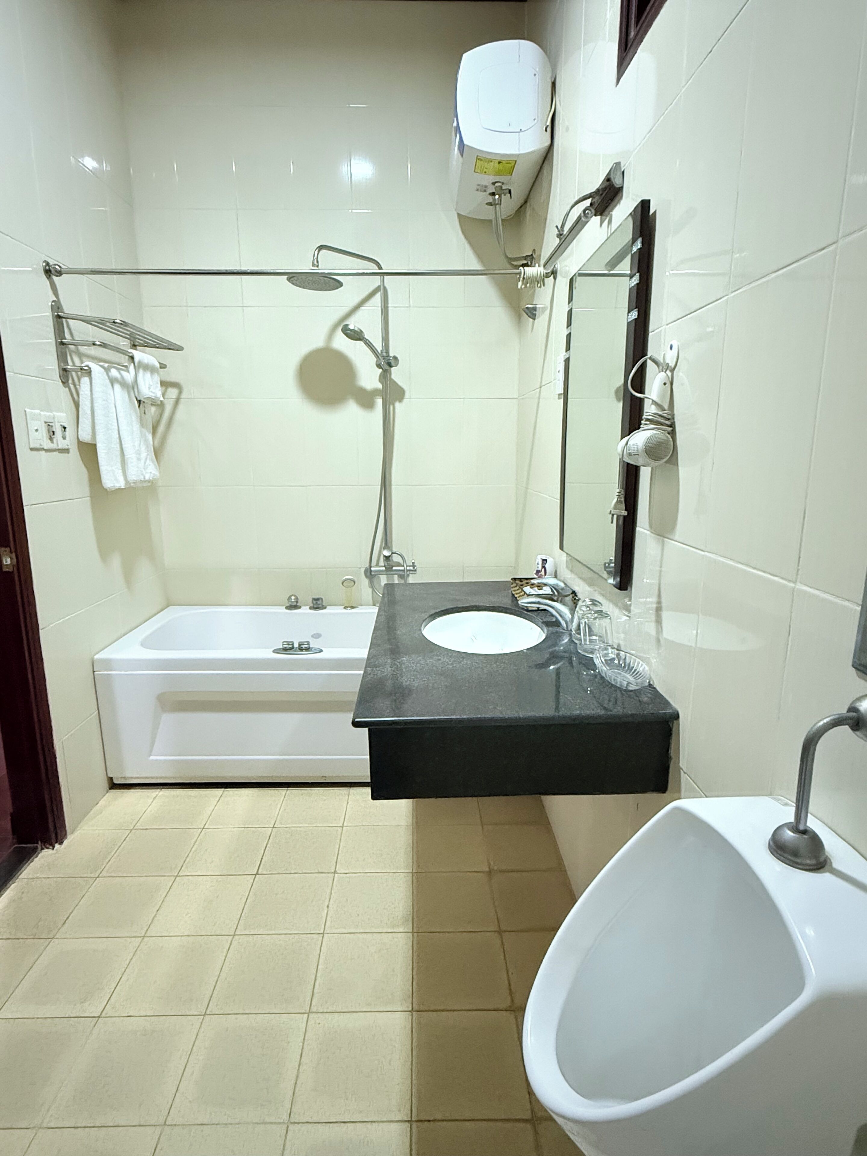Ein modernes Badezimmer mit Badewanne, Waschbecken und einer Urinalschale.