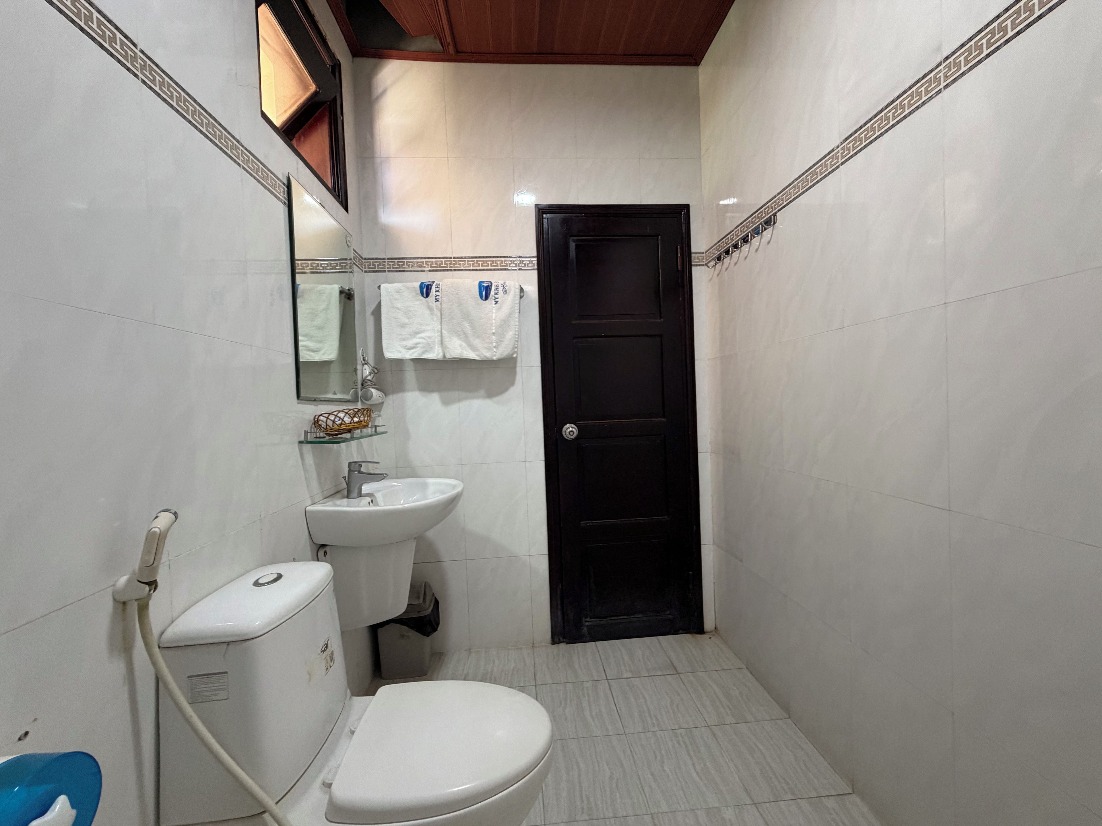 A small bathroom with a toilet, sink, and mirror.
