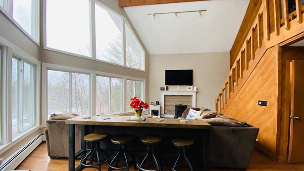A modern kitchen with a large island, bar stools, and a fireplace. - Mountain View, Dogs OK, 2 Kitchens, Screened Deck, Pool Table, North Conway (Conway)