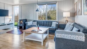 Un salon moderne comprenant un canapé, une table basse, un téléviseur et une cheminée.