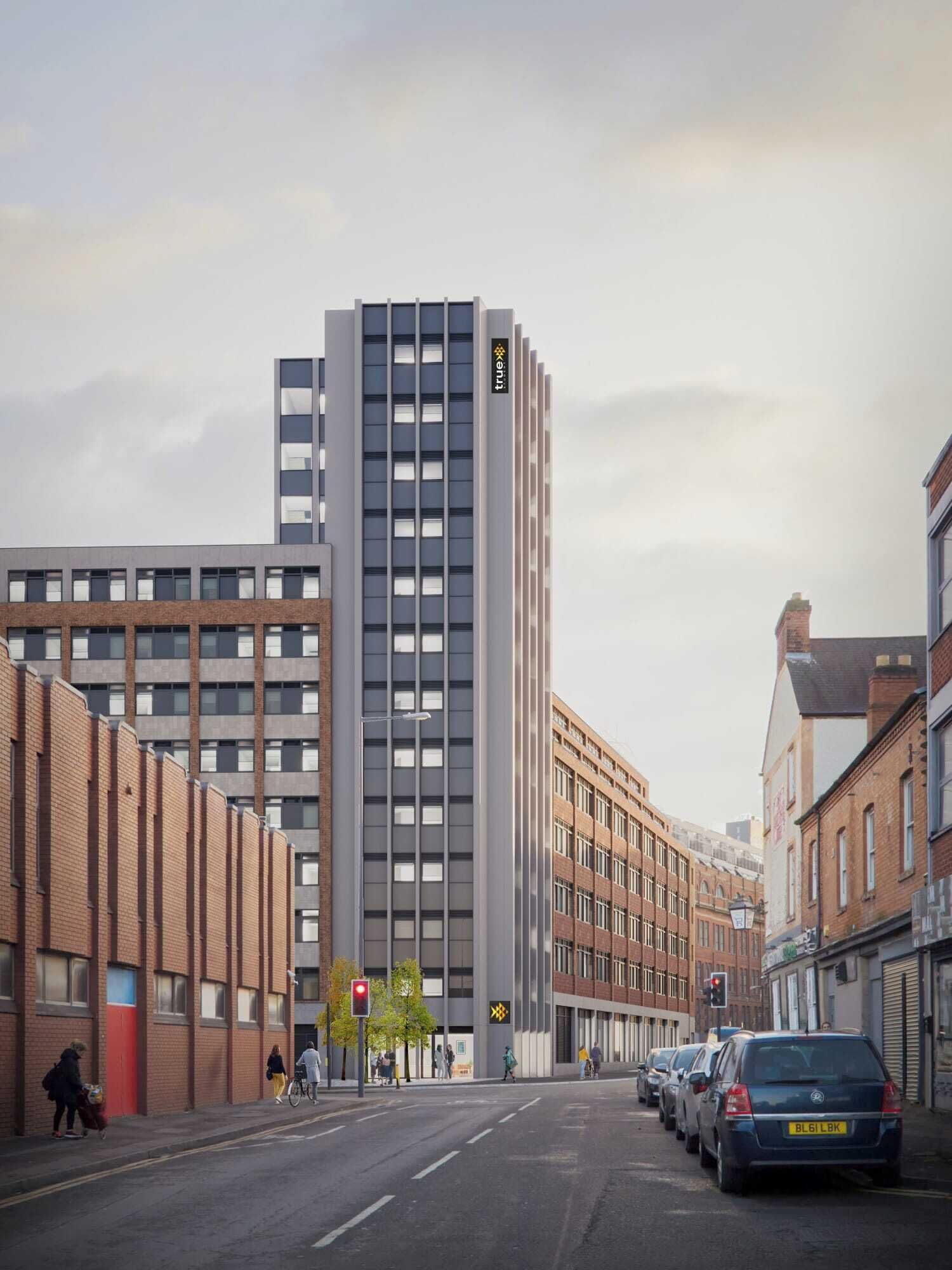 Een moderne straat in de stad met een hoog gebouw met een 'true' logo, omlijst door bakstenen gebouwen, en een heldere lucht.