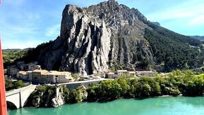 A river with a rocky cliff and a bridge. - Le Clos Androne (Sisteron)