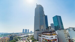 Eine Stadtansicht mit modernen Hochhäusern, einem Fluss und einer Mischung aus Wohn- und Geschäftsgebäuden.
