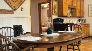 A dining room with a wooden table, chairs, and a ceiling fan. - Lake Huron views, ideally located in Eastern UP.Has deck, wildlife, and privacy. (Hessel)