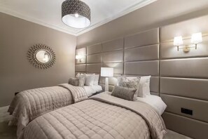 A bedroom with two beds, a decorative wall mirror, and a modern light fixture. - Family/small Group - Parking - Wifi - Sleeps 6 (Edinburgh)