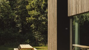 A modern building with a wooden exterior and a glass entrance. - Fantastic vacation rental with wide views of valley, forest and own vineyard! (Zonnebeke)