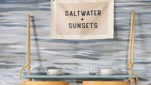 A wooden chair and table with a sign above them reading "Saltwater & Sunsets". - Relax and Play - Heated Pool + Game Shed + Minutes to the Beach (St. Augustine)