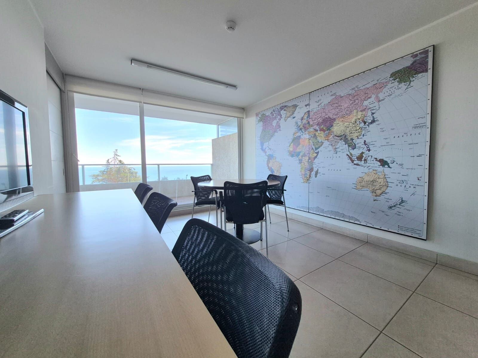 Une salle de conférence équipée d’une grande carte du monde, d’une longue table et de chaises.