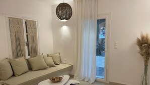 Un saló modern amb un sofà, una taula petita i una làmpada decorativa penjada.