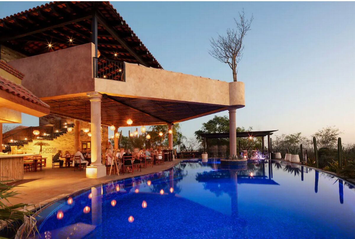 A poolside area with a bar, outdoor seating, and a covered patio.