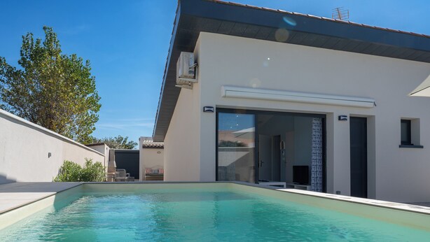A modern house with a swimming pool, a covered patio, and a large sliding glass door leading to a covered outdoor area. - Riboleys - Villa 10 personnes avec piscine privée à 200m de la mer (Vias)