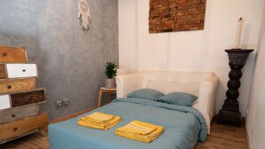 A bedroom with a bed, a dresser, a plant, and a wall-mounted decoration. - Charmante maison climatisée à 500m de la plage (Vias)