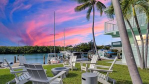 Un puerto deportivo con barcos, una zona ajardinada con sillas de descanso y un edificio que dice 'Ocean View Marina'.
