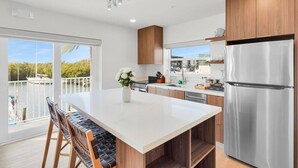 Una cocina moderna con una isla grande, electrodomésticos de acero inoxidable y vistas al agua.