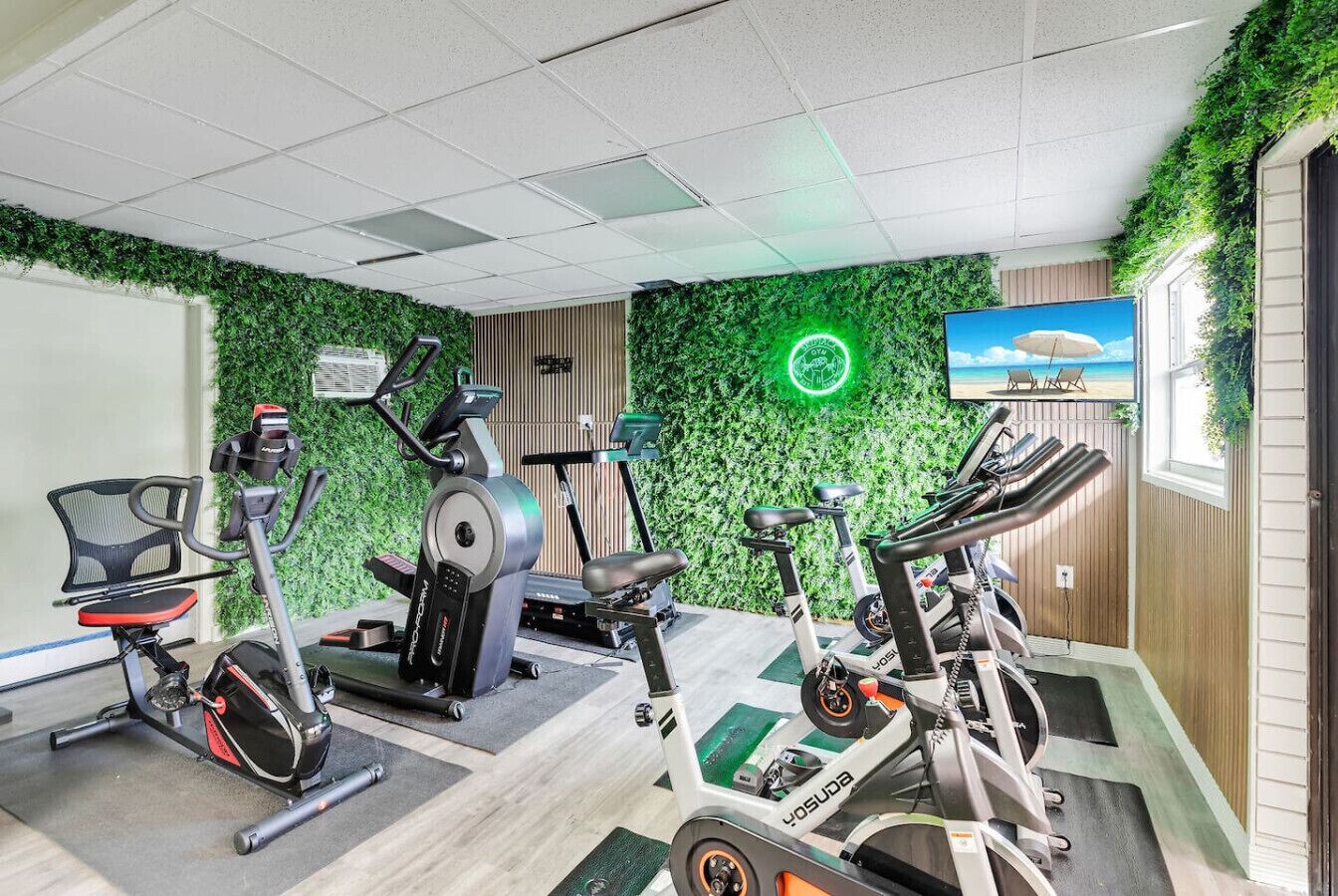 A gym with stationary bikes, a treadmill, and a rowing machine.